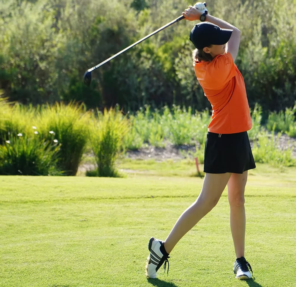 Golfer taking a full swing on a course
